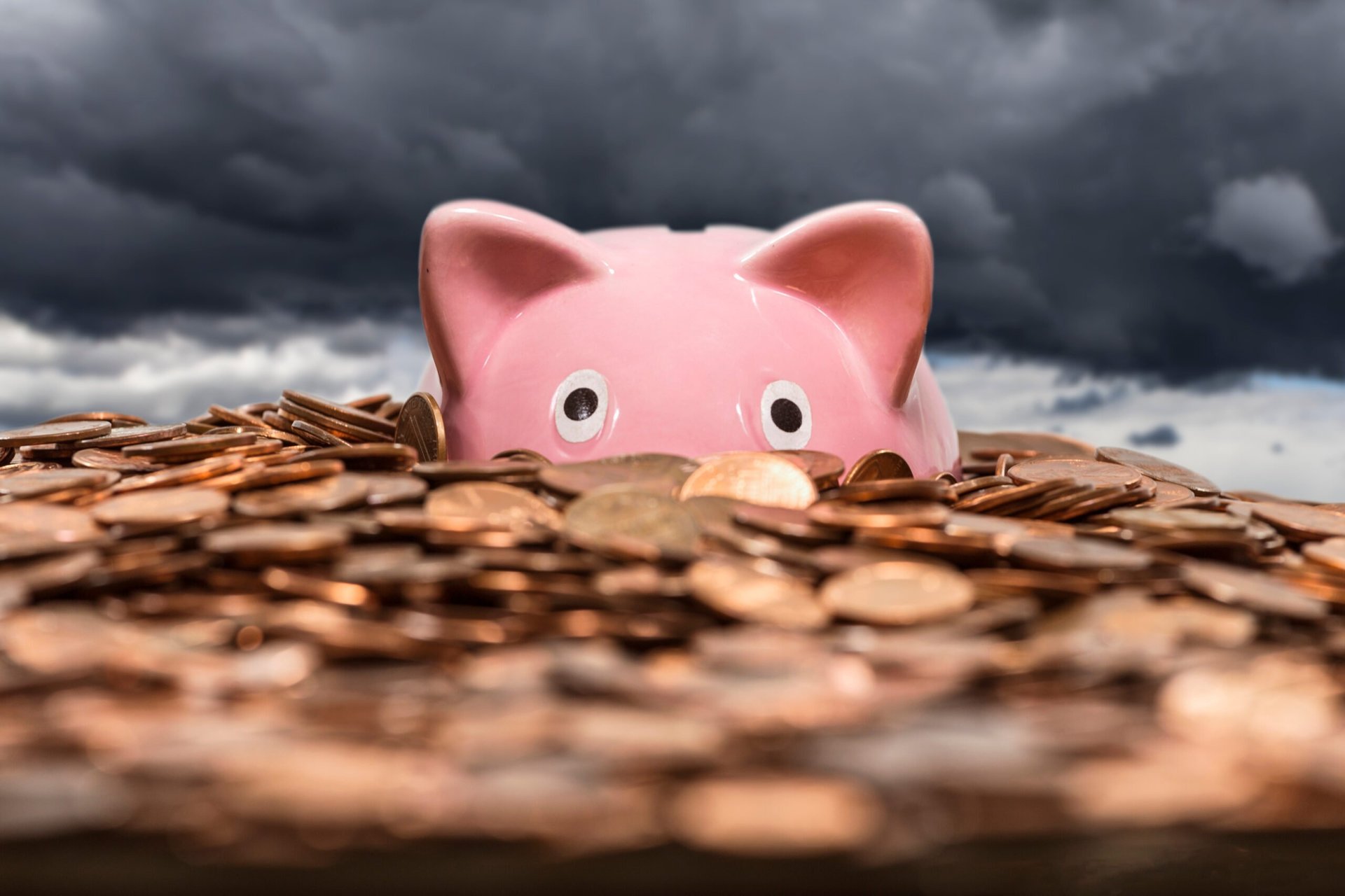 Piggy bank drowning in pile of pennies