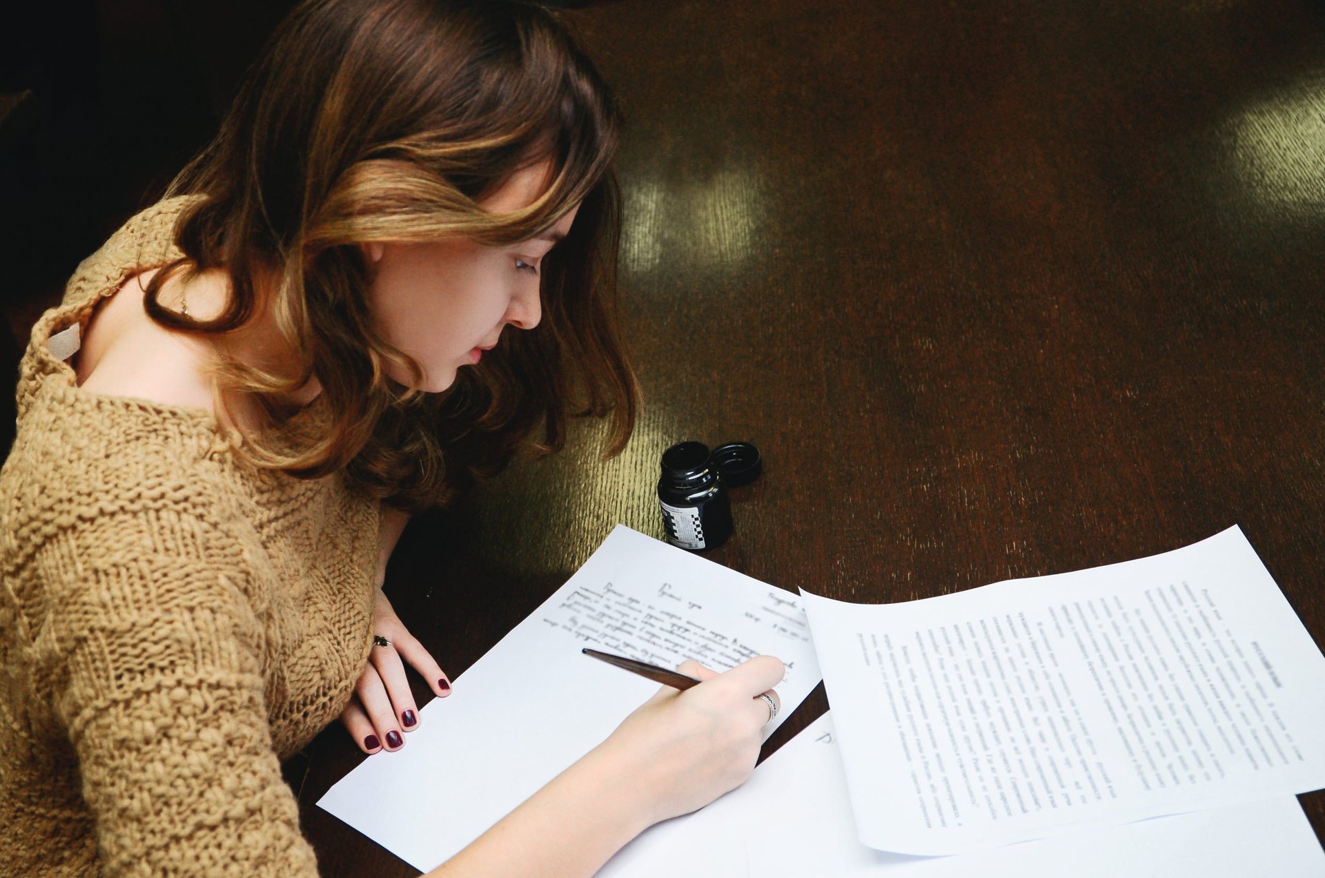 A woman writes with a pen