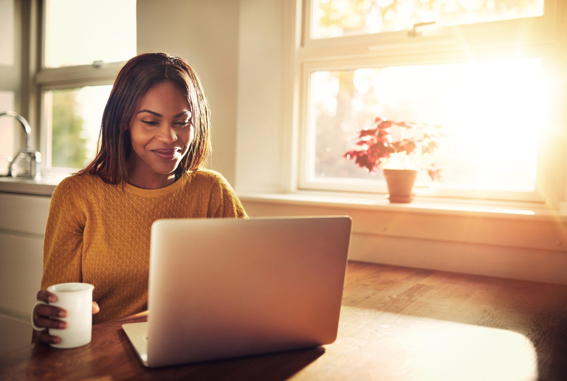 Woman using a laptop and drinking coffee