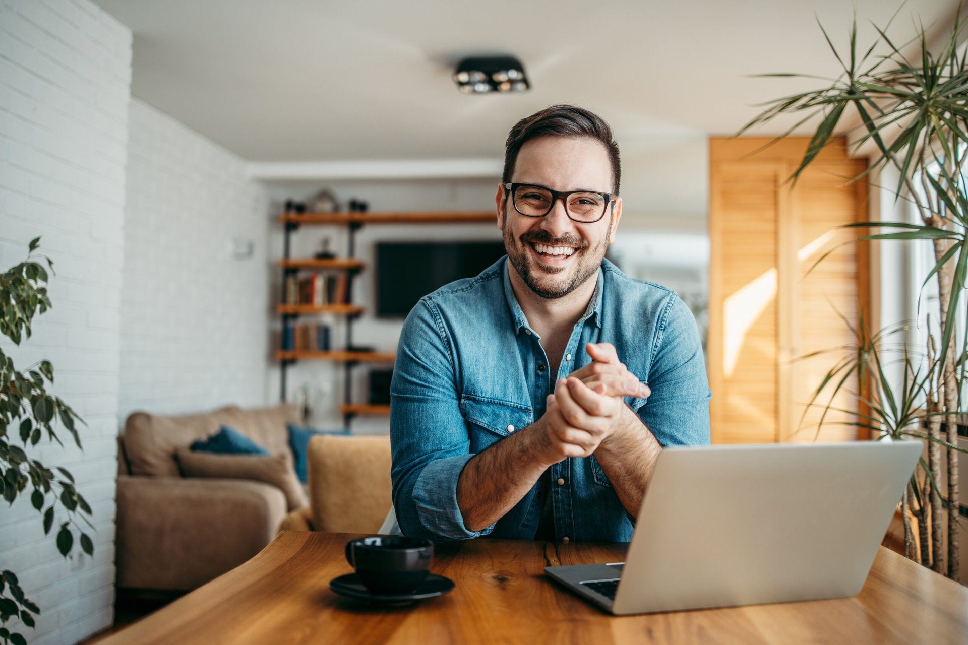 Happy man working in home office on laptop